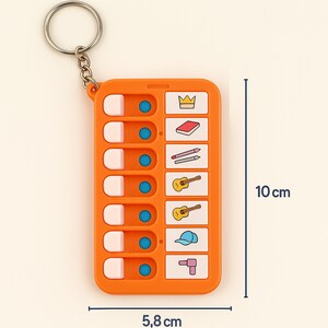 May include: Orange keychain with a sliding game featuring 8 different icons, including a crown, a book, pencils, a guitar, a hat, and a drill. The keychain measures 5.8 inches by 10 inches.