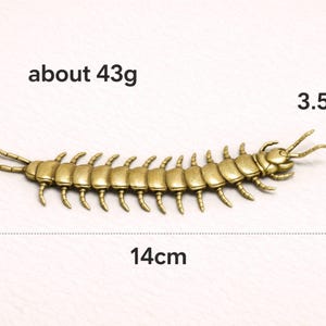 May include: A detailed, antique gold-colored centipede figurine, approximately 5.5 inches long and 1.4 inches wide, weighing about 1.5 ounces. The insect-like sculpture has multiple legs and antennae, and is a decorative item.