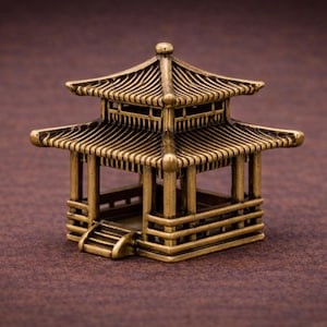 Può includere: Una piccola pagoda dorata con dettagli architettonici intricati. La pagoda presenta più livelli, un tetto curvo e una piccola scala. La struttura metallica poggia su una superficie marrone. Misura circa 5 cm di altezza.