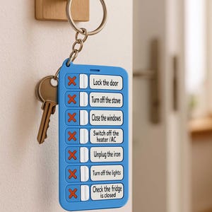 Puede incluir: Un llavero azul con una lista de verificación de tareas para completar antes de salir de casa. La lista incluye elementos como cerrar la puerta con llave, apagar la estufa y revisar el refrigerador. Un juego de llaves cuelga junto al llavero.