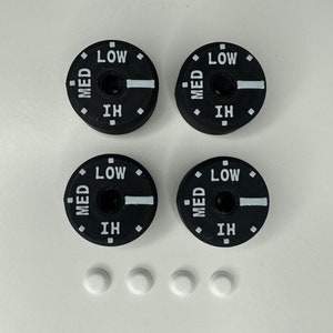 May include: Four black round knobs with white lettering that reads "LOW", "MED", and "HI". There are three white round discs below the knobs.