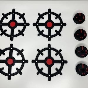 May include: Four black stovetop burner covers with a red centre circle and four black knobs with a red accent.
