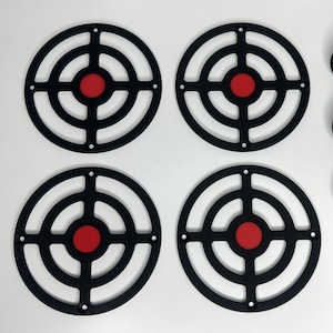 May include: Four black metal circular targets with red centres. Each target has four concentric circles and a crosshair in the centre.