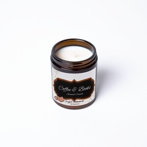 May include: A brown glass jar candle with a white wax interior. The label reads "Coffee & Books" in a decorative font. The candle is labeled "Joyful Candles GB" and is made with soy coconut wax.