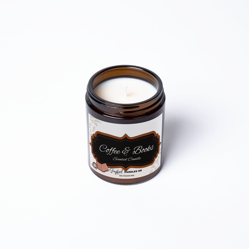 May include: A brown glass jar candle with a white wax interior. The label reads "Coffee & Books" in a decorative font. The candle is labeled "Joyful Candles GB" and is made with soy coconut wax.