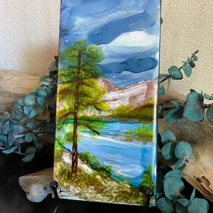 Hand Painted Alcohol Ink on 3x6” ceramic tile, epoxy resined: “Mountain Lake Retreat”.  Easel included.