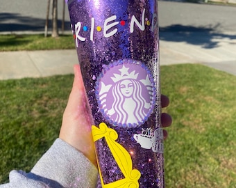 Może przedstawiać: Fioletowy kubek z brokatem z logo Starbucks, żółtą ramką i napisem "FRIENDS" w kolorze czarnym z kolorowymi kropkami.
