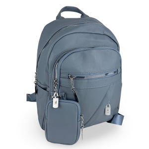May include: A dusty blue backpack with a textured surface, featuring multiple zippered compartments, silver-toned hardware, and a small detachable matching pouch hanging from a silver chain attached to the front zipper pull.