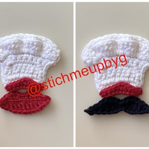 May include: Two crocheted chef hats with different coloured moustaches. One moustache is red and the other is black. The hats are white and the moustaches are attached to the bottom of the hats.