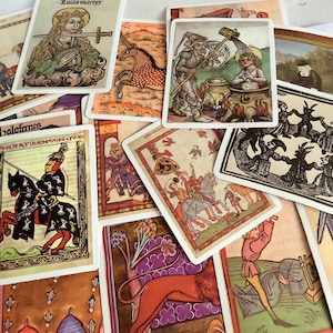 May include: A selection of vintage tarot cards with medieval illustrations. The cards depict knights, saints, and mythical creatures in various colours, including red, gold, and green. Some cards have text in a stylized font.