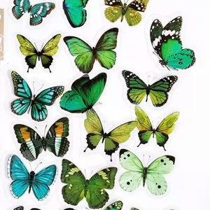 May include: A sheet of colourful butterfly stickers featuring various shades of green, blue and yellow. The butterflies are in different sizes and positions, creating a vibrant and whimsical design.