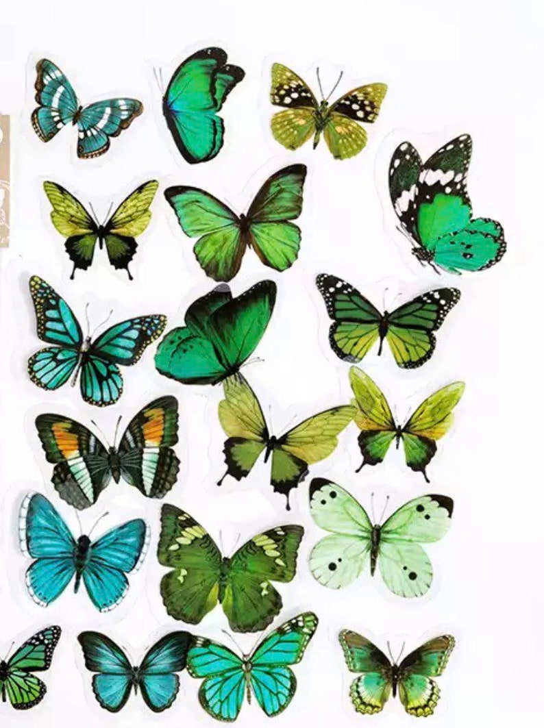 May include: A sheet of colourful butterfly stickers featuring various shades of green, blue and yellow. The butterflies are in different sizes and positions, creating a vibrant and whimsical design.