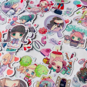 May include: A collection of colourful stickers featuring cartoon characters with different expressions and poses. The stickers are on a white background and include a variety of themes, such as animals, food, and everyday activities. Some of the stickers have text, such as "Call me".