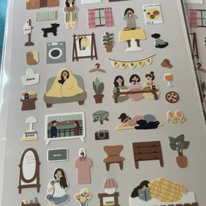 K&ouml;nnte beinhalten: Ein Set mit 30 illustrierten Aufklebern, die verschiedene Szenen aus dem Alltag zeigen, darunter ein Haus, eine Party, ein Schlafzimmer und ein Wohnzimmer. Die Aufkleber sind auf wei&szlig;em Papier gedruckt und haben eine matte Oberfl&auml;che.