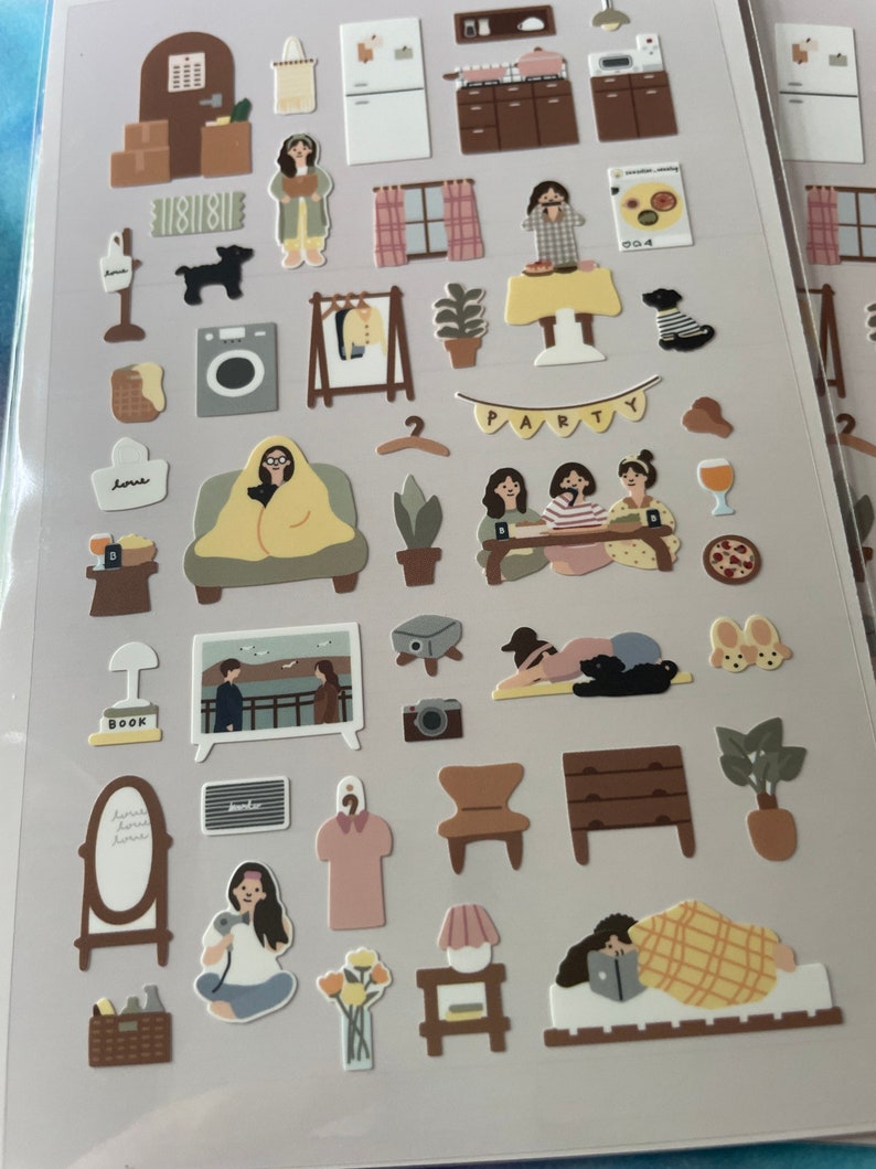 K&ouml;nnte beinhalten: Ein Set mit 30 illustrierten Aufklebern, die verschiedene Szenen aus dem Alltag zeigen, darunter ein Haus, eine Party, ein Schlafzimmer und ein Wohnzimmer. Die Aufkleber sind auf wei&szlig;em Papier gedruckt und haben eine matte Oberfl&auml;che.