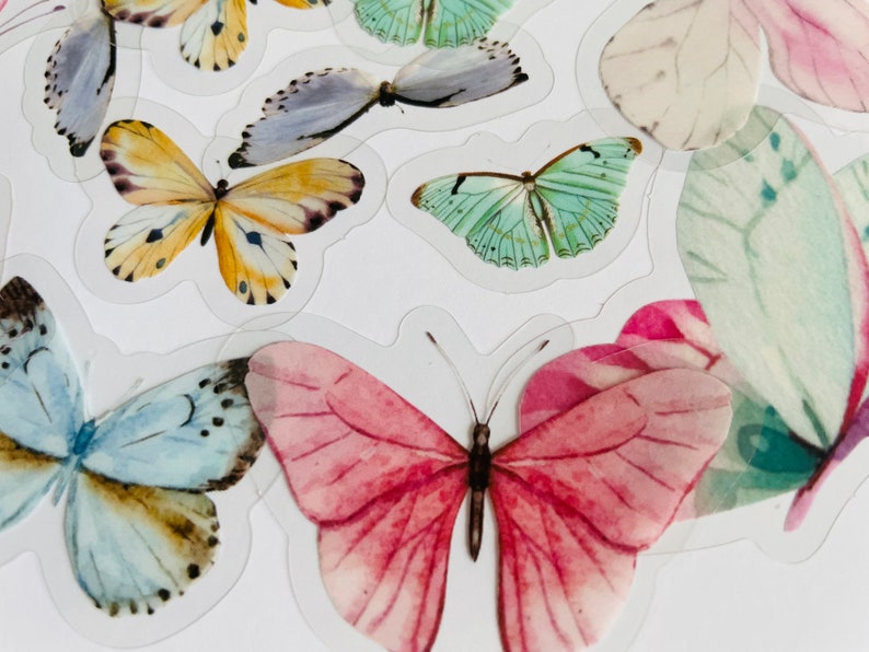 May include: A sheet of colourful butterfly stickers. The stickers feature butterflies in various colours, including pink, blue, green, and yellow. The butterflies are all different sizes and shapes.