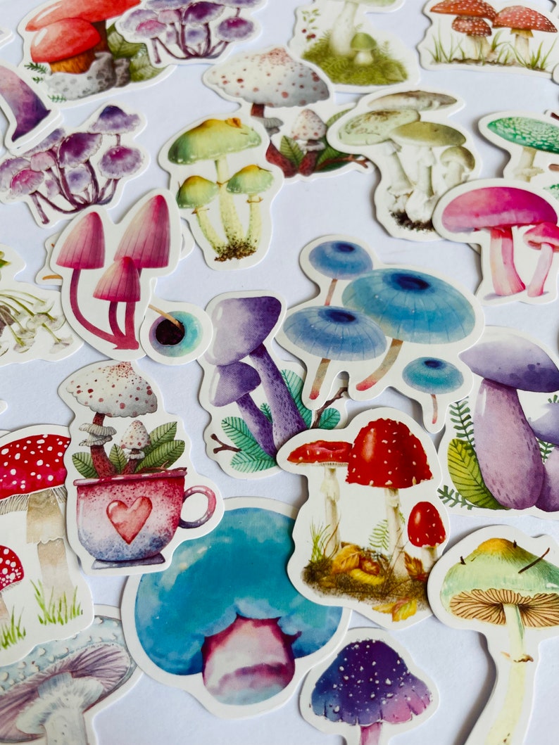 May include: A collection of colorful mushroom stickers with various designs, including red and white polka dot mushrooms, blue mushrooms, and purple mushrooms.