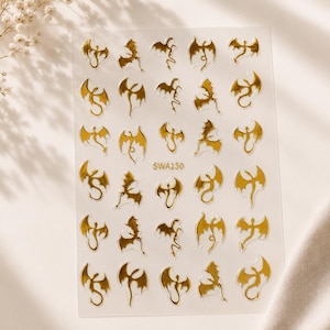 May include: A clear sheet of adhesive nail decals featuring various gold metallic dragon silhouettes in different poses. The sheet contains thirty individual dragon designs arranged in a grid, with the text SWA130 printed in gold in the center.