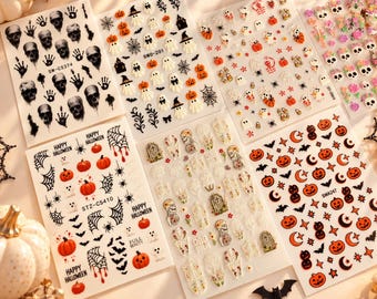May include: Six sheets of adhesive nail art stickers featuring Halloween themes including skulls, ghosts, pumpkins, spider webs, bats, tombstones, and floral sugar skulls. Each sheet contains various small, detailed decals for nail decoration.