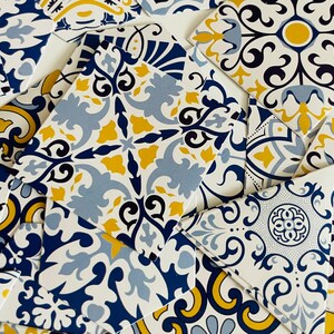 May include: A collection of decorative ceramic tiles with a blue, yellow, and white geometric pattern. The tiles are arranged in a random pattern, creating a visually appealing design.