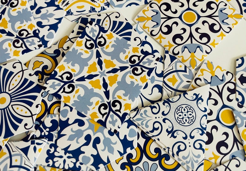 May include: A collection of decorative ceramic tiles with a blue, yellow, and white geometric pattern. The tiles are arranged in a random pattern, creating a visually appealing design.