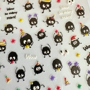 May include: Sheet of stickers featuring cartoonish black creatures with expressive eyes and limbs, some wearing party hats. The stickers include the text "Wow so many stars!" and various star and confetti designs.