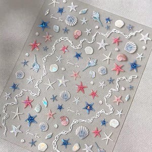 May include: A clear sheet of stickers featuring various sea-themed designs. The stickers include starfish in pink, blue, and white, along with seashells and a white, wavy line design. The text "Summer Time" is also present.