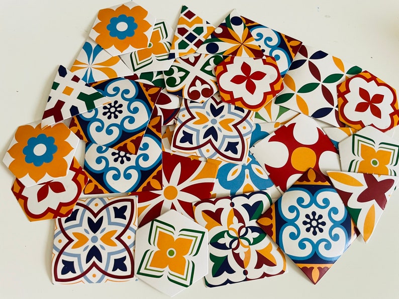 May include: A collection of colorful patterned ceramic tiles with geometric designs in shades of blue, red, yellow, and green. The tiles are arranged in a random pattern, creating a visually appealing and vibrant display.