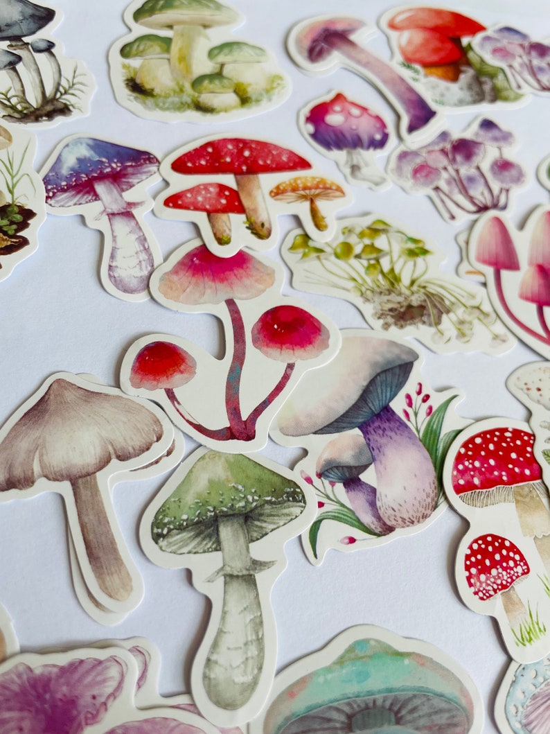 May include: A collection of colorful mushroom stickers with various designs, including red and white polka dot mushrooms, green mushrooms with white spots, and purple mushrooms with white stems.