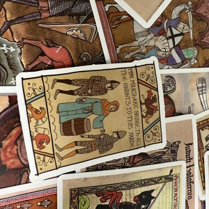 May include: A selection of medieval-themed cards, depicting knights, soldiers, and historical scenes. The cards showcase detailed illustrations with a vintage appearance, incorporating text and decorative borders. The colour scheme includes browns, reds, and blues.