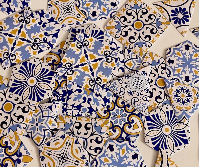 May include: A collection of blue and gold patterned ceramic tiles with intricate designs. The tiles are arranged in a random pattern, creating a visually appealing mosaic.