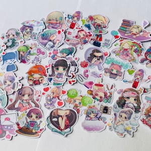 May include: A collection of colourful stickers featuring cartoon characters with various expressions and poses. The stickers are mostly pink, blue, and green with white outlines. Some stickers have text, including "Call me" and "Thank you".