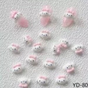 K&ouml;nnte beinhalten: Eine Sammlung von 20 kleinen, wei&szlig;en 3D-Harz-Anh&auml;ngern in Form einer Wolke mit einer rosa Schleife. Die Anh&auml;nger sind perfekt, um Nagelkunst, Schmuck oder anderen Bastelarbeiten eine s&uuml;&szlig;e und skurrile Note zu verleihen.