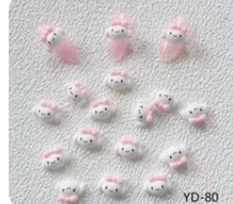 K&ouml;nnte beinhalten: Eine Sammlung von 20 kleinen, wei&szlig;en 3D-Harz-Anh&auml;ngern in Form einer Wolke mit einer rosa Schleife. Die Anh&auml;nger sind perfekt, um Nagelkunst, Schmuck oder anderen Bastelarbeiten eine s&uuml;&szlig;e und skurrile Note zu verleihen.