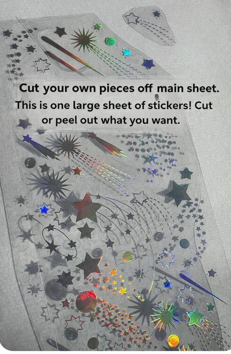 May include: A sheet of holographic stickers featuring star and comet designs in various sizes and colors. The text on the sheet reads, "Cut your own pieces off main sheet. This is one large sheet of stickers! Cut or peel out what you want."