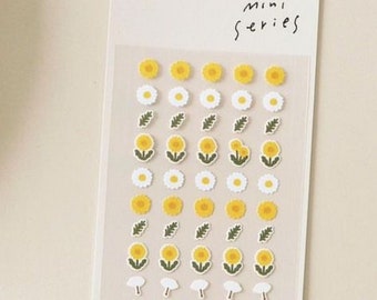 May include: A sheet of clear sticker paper with yellow and white flower stickers. The stickers are arranged in rows and feature different variations of flowers with green leaves. The sheet is labeled "mini series" and "FLOWER.02".
