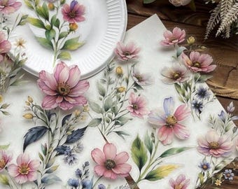 May include: Watercolor floral stickers with pink, purple, and blue flowers and green leaves. The stickers are arranged on a white surface with a white plate in the background. The stickers have a delicate, artistic design.