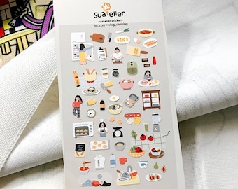 May include: A sheet of stickers featuring illustrations of food, kitchen appliances, and people cooking. The stickers are on a light grey background and feature a variety of colours, including red, yellow, green, blue, and brown. The text "Sua*telier" and "no.1137 : vlog_cooking" is printed on the sheet.