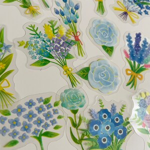 May include: A sheet of clear stickers featuring various blue and green floral bouquets. The bouquets are arranged in a random pattern on a white background.