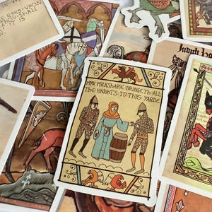 May include: A selection of medieval-themed art cards, featuring illustrations and text. The cards depict knights, figures in armour, and text in a vintage style. The colour scheme includes beige, brown, and muted tones, creating a historical aesthetic.