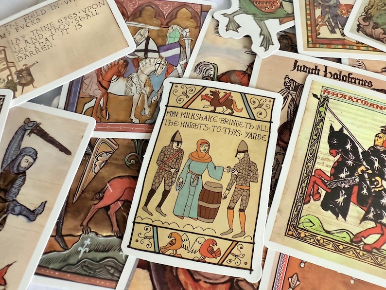 May include: A selection of medieval-themed art cards, featuring illustrations and text. The cards depict knights, figures in armour, and text in a vintage style. The colour scheme includes beige, brown, and muted tones, creating a historical aesthetic.