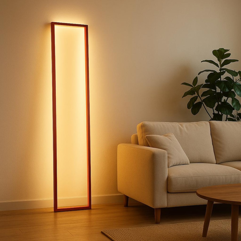 Front view of warm-lit minimalist floor lamp in modern living space. Sleek black frame casts soft glow on neutral walls. Perfect for cozy evenings.