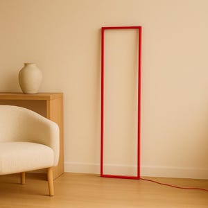 Front view of  minimalist floor lamp in modern living space. Sleek red frame is guarding the space like a gate. Perfect for cozy evenings and well balanced interiors, for calm and peace atmosphere.