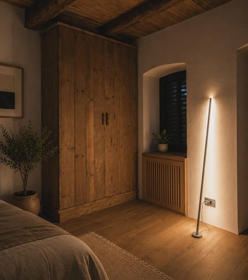 Bright rustic living room with wooden beams, beige sofa, natural textures and handcrafted minimalist lamps by Tommaso Cristofaro creating warm atmospheric light.