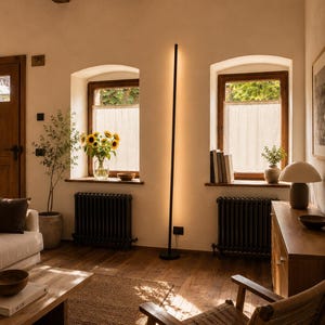 Bright rustic living room with wooden beams, beige sofa, natural textures and handcrafted minimalist lamps by Tommaso Cristofaro creating warm atmospheric light.
