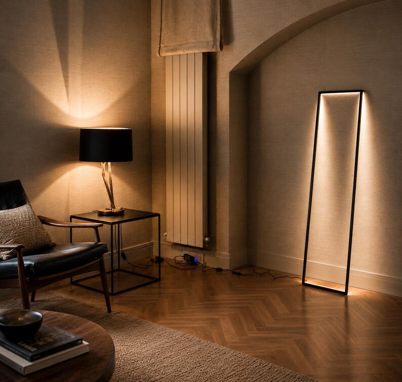Pode incluir: Uma sala de estar moderna com um candeeiro de p&eacute; preto e um candeeiro de mesa. O candeeiro de p&eacute; tem uma estrutura retangular com luz brilhante. O candeeiro de mesa tem uma sombra preta e uma base dourada. Uma cadeira preta e uma mesa de madeira tamb&eacute;m est&atilde;o presentes.