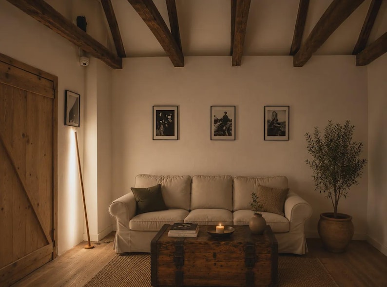 Bright rustic living room with wooden beams, beige sofa, natural textures and handcrafted minimalist lamps by Tommaso Cristofaro creating warm atmospheric light.