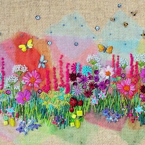 May include: A colorful embroidered artwork depicting a field of wildflowers with butterflies and bees. The flowers are in shades of pink, purple, blue, and white, and the background is a soft watercolor wash of pink, blue, and green.