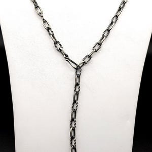 May include: A silver chain necklace with a twisted design. The chain is made of oval links and has a lobster clasp.