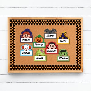 Puede incluir: Un tablero de corcho con un borde de lunares negros y naranjas. Hay ocho etiquetas de nombre con tem&aacute;tica de Halloween con diferentes personajes, incluyendo una bruja, un vampiro, un zombi y un Frankenstein. Los nombres en las etiquetas son Jackie, Jocelyn, Johnny, Kate, Lamar, Jacob, Alexander y Michael.